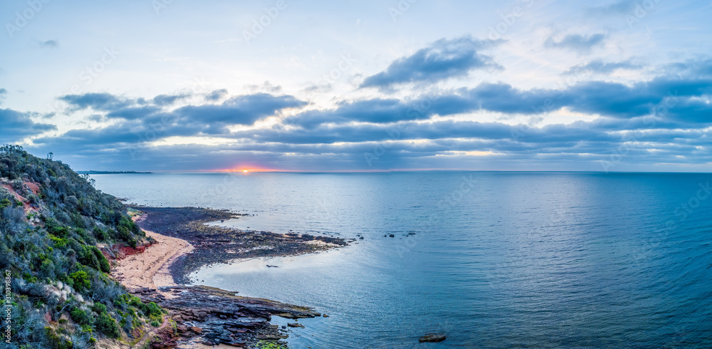 Sunset over ocean near the coastline - aerial panorama
