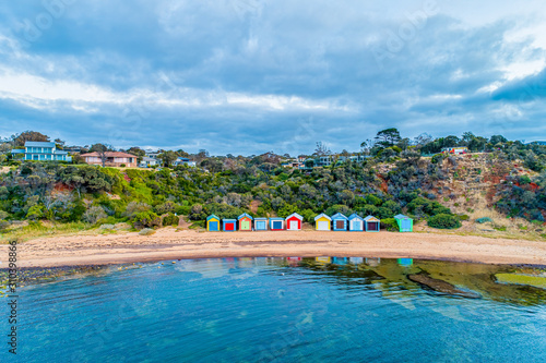 Colorful bathing boxes with reflections on ocean beach in Melbourne, Australia