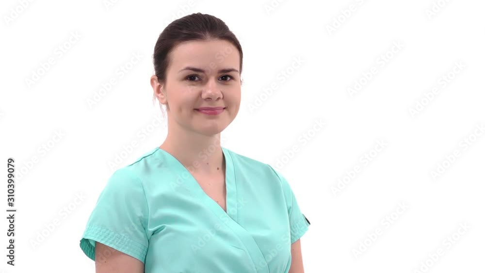Close-up of a beautiful young female doctor smiling at camera and winking her eye. Concept of profession, medicine and healthcare, medical education Close-up of a beautiful young female doctor smiling at camera and winking her eye. Concept of profession, medicine and healthcare, medical education