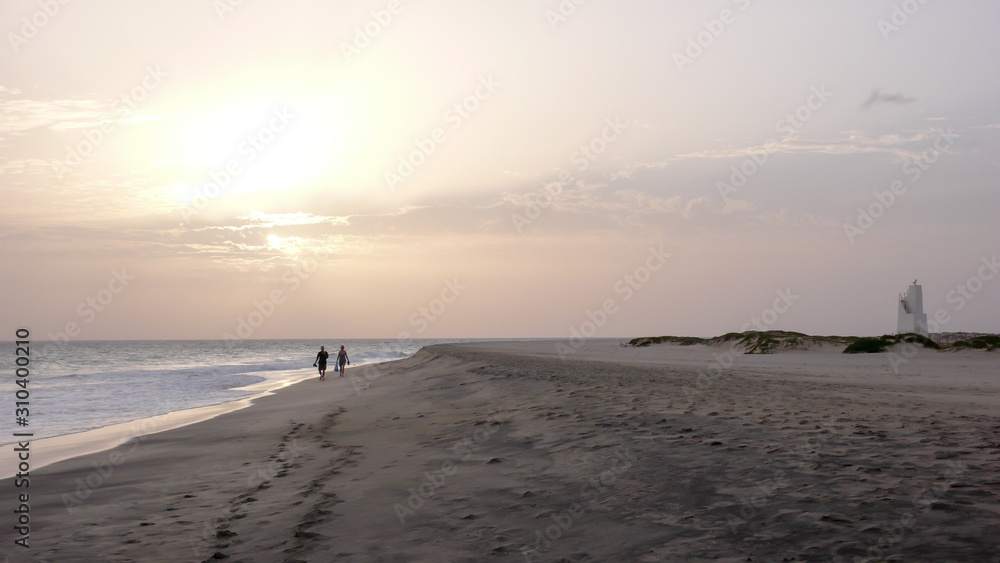 couple enjoying a sunset walk on a secluded beach in Cape Verde