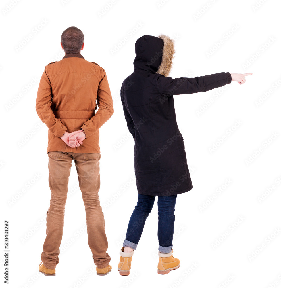 Back view of couple couple in winter jackets pointing. Back view of couple couple in winter jackets pointing.