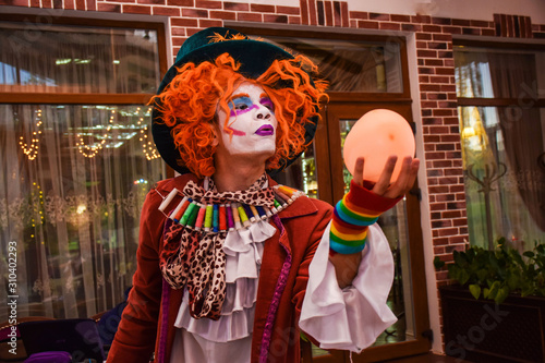 The character from “Alice's Adventures in Wonderland” by Lewis Carroll is a Dummy or a Shoemaker. A young man in a suit of a mad, surprised Hatter entertains guests in a cafe.