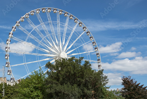 wallpaper with a view of the ferris wheel on a background of blue sky with clouds