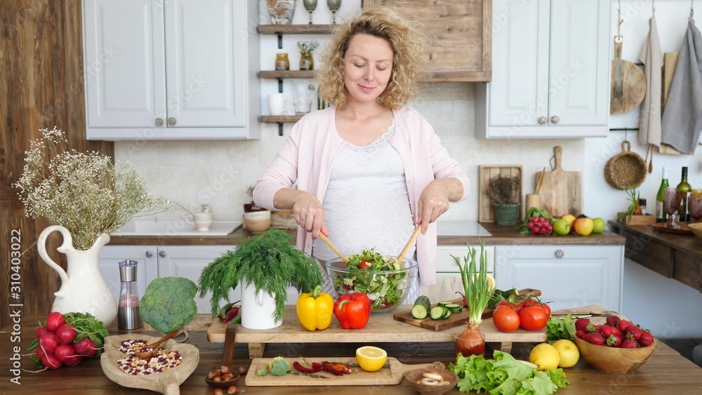 Happy Pregnant Woman Cooking Healthy Salad In Kitchen. Happy Pregnant Woman Cooking Healthy Salad In Kitchen.
