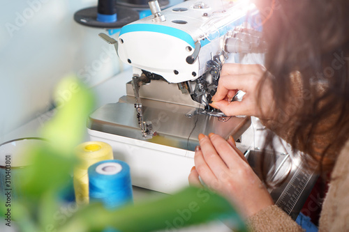 Workplace of seamstress. Tailor works with sewing machine. photo