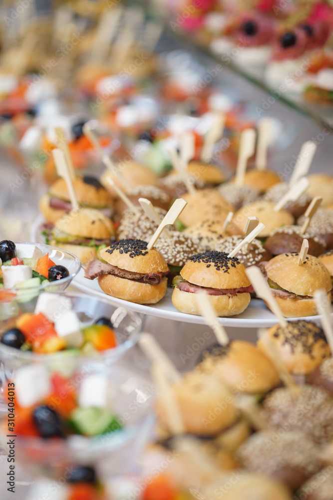 Mini burgers with meat and fish on the table prepared for the guests of the event.