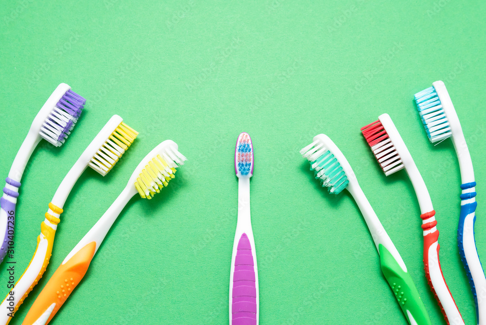 plastic colored toothbrushes on green background plastic colored toothbrushes on green background