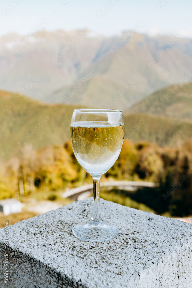 Glass of white wine on the background of beautiful mountains