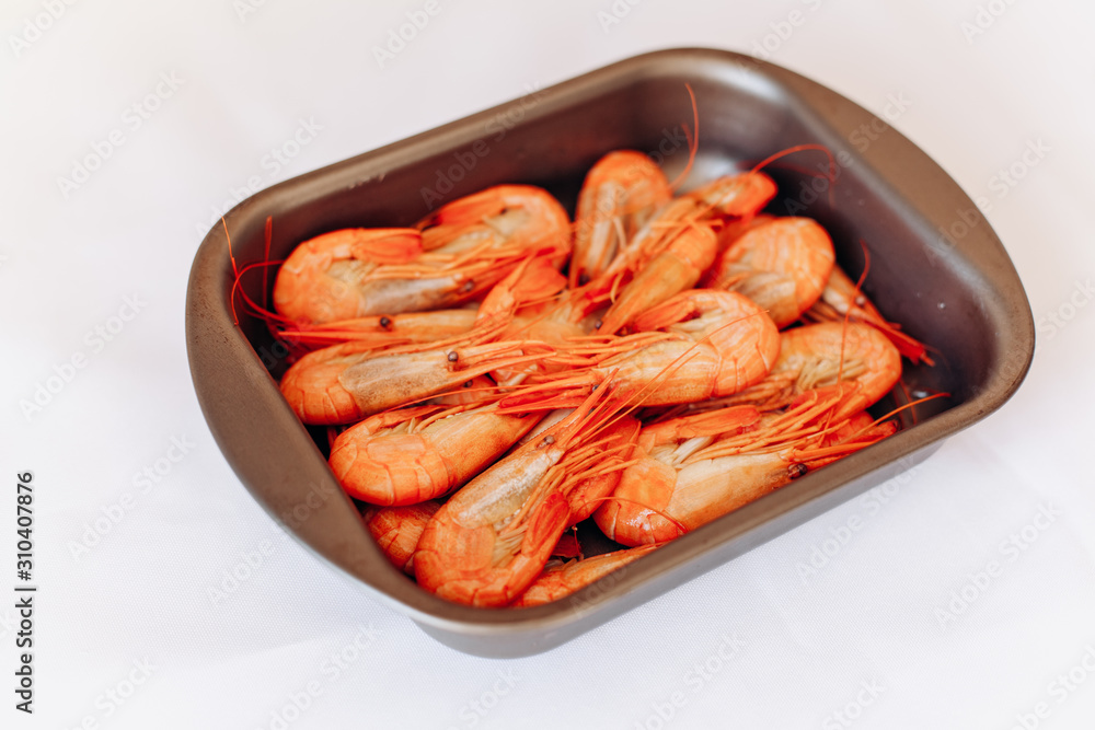 Bowl of fresh shrimp on white background