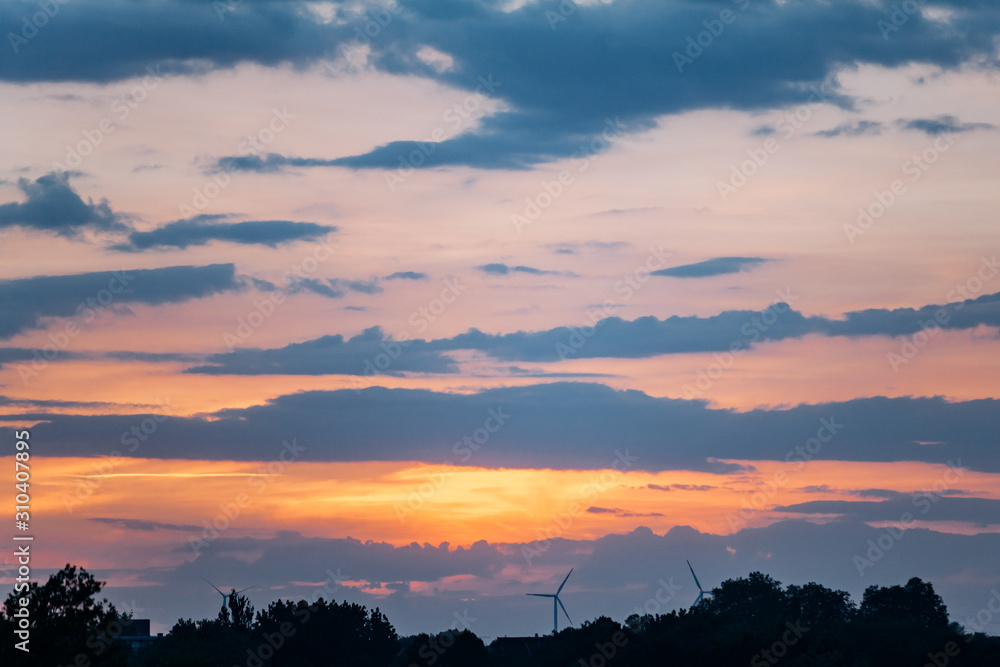 Fototapeta premium The sun at sunset behind the clouds. Beautiful sunset