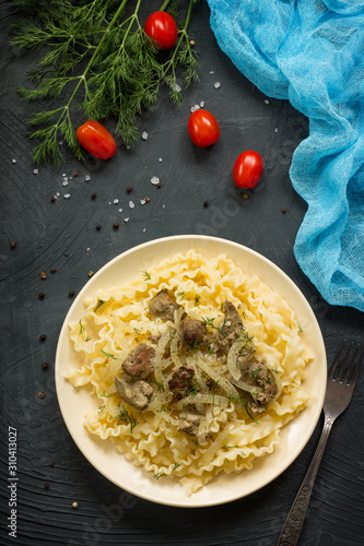 Italian Cuisine. Pasta with meat liver and onion sauce on a stone table. Top view on a flat background lay.