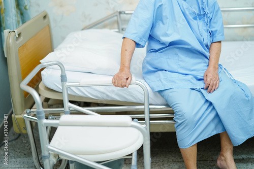 Asian senior woman patient with commode chair or mobile toilet can moving in bedroom or everywhere for elderly old disabled people or patient : healthy strong medical concept ..