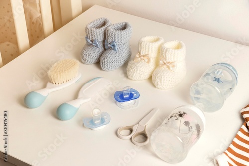 baby clothes and hygiene items on white table. baby accessories