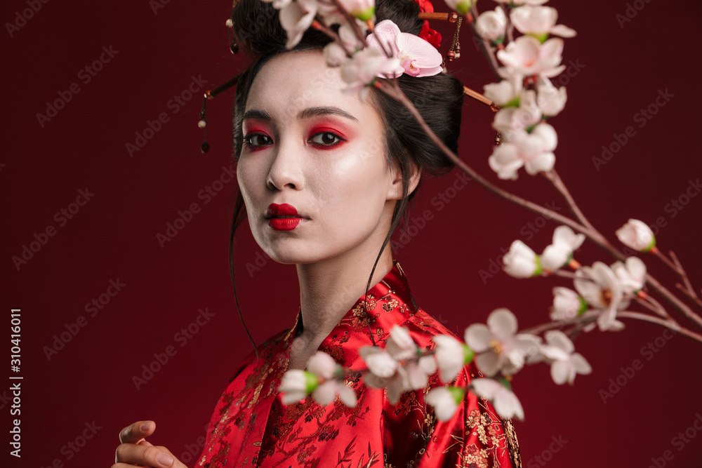 Image of geisha woman in traditional japanese kimono with sakura tree