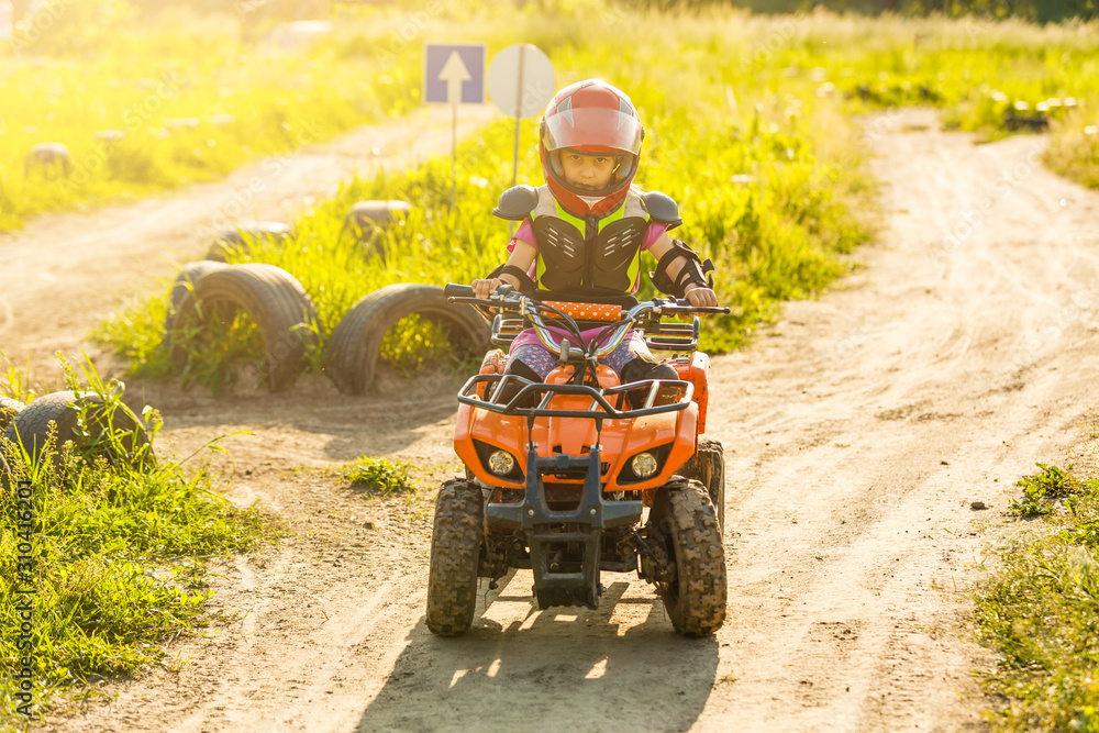 Little girl riding ATV quad bike in race track Little girl riding ATV quad bike in race track