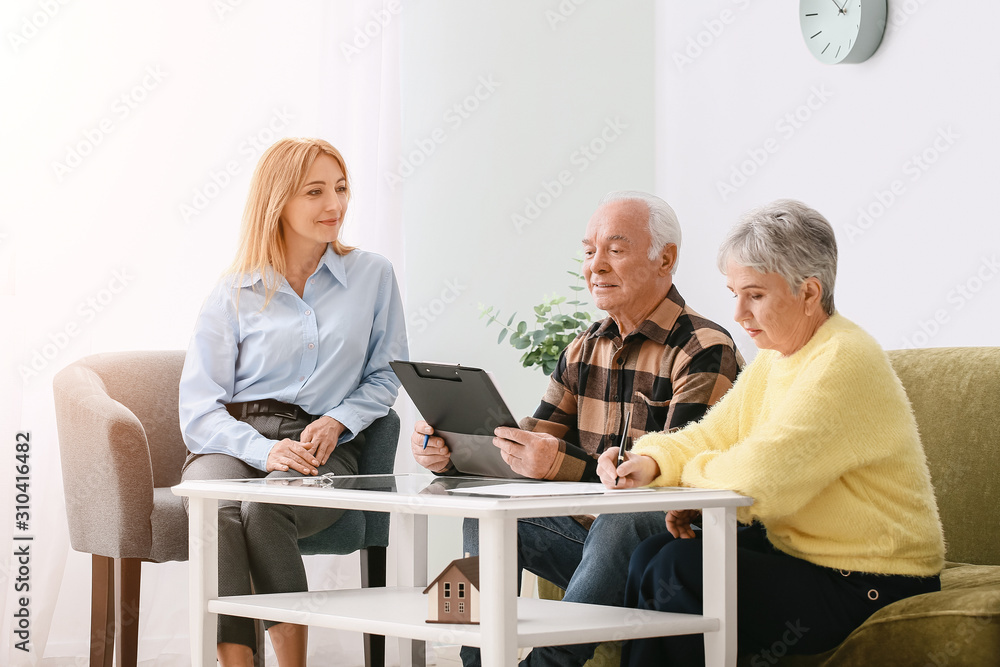 Female real estate agent working with senior couple indoors Female real estate agent working with senior couple indoors