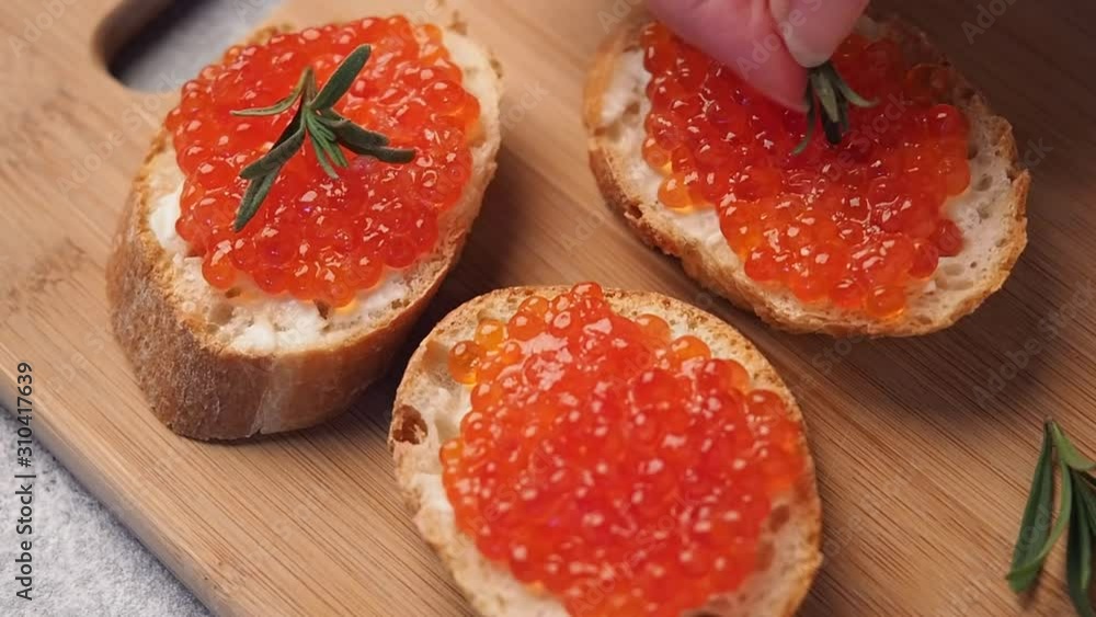 Sandwich with red caviar. Decoration with a green sprig of rosemary appetizer of red caviar. Sandwich with red caviar. Decoration with a green sprig of rosemary appetizer of red caviar.