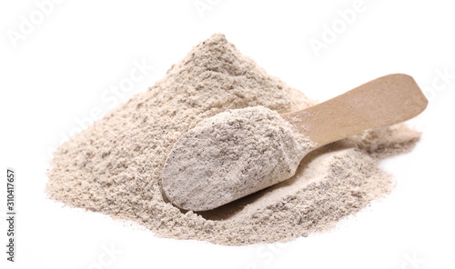 Buckwheat integral flour pile with wooden spoon isolated on white background 