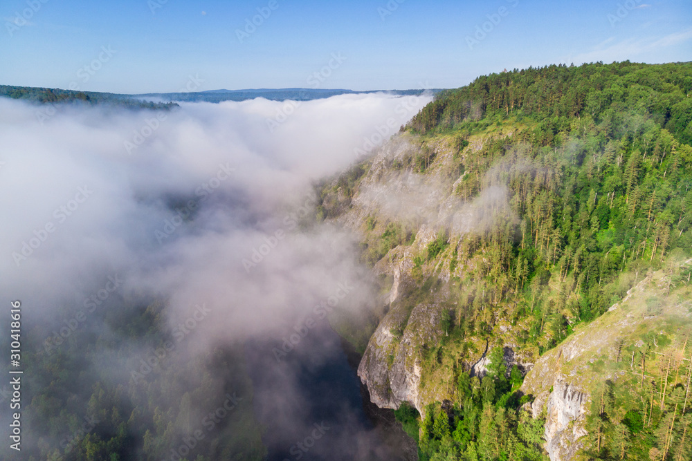 Misty clouds over a mountain forest. View from above.