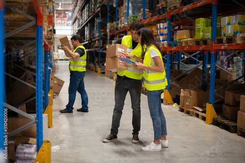 Workers in warehouse review the goods