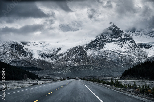 Road trip with snowy rocky mountains in gloomy at Icefields Parkway