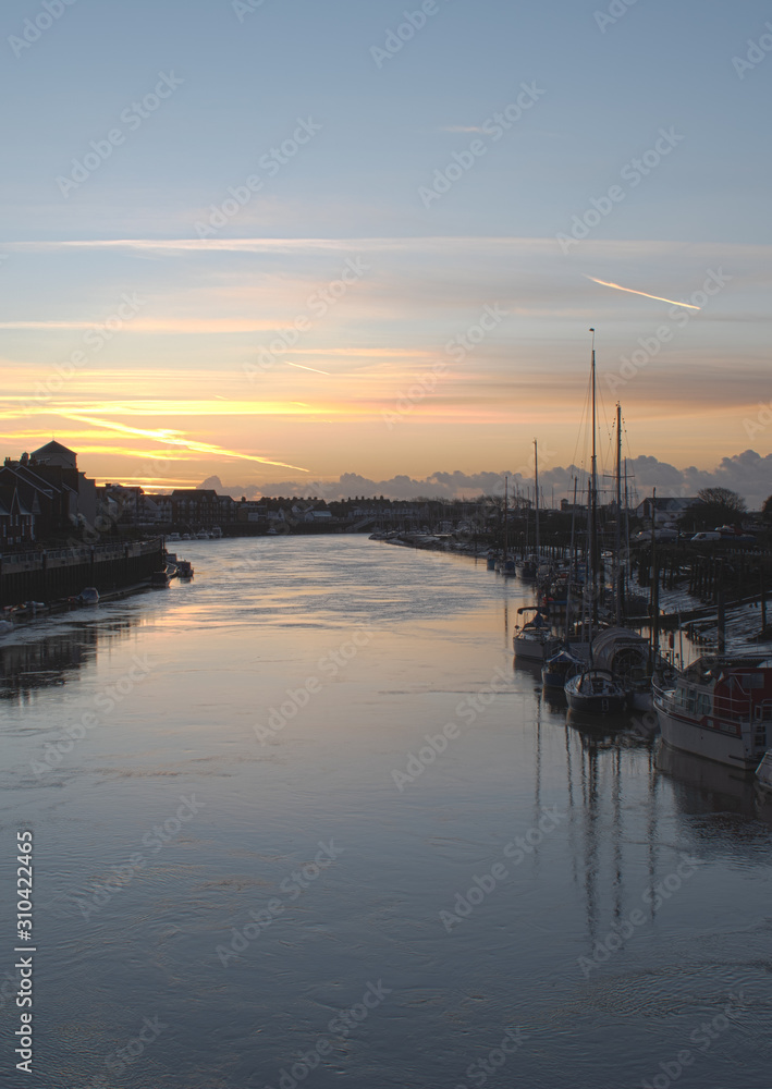 Beautiful Sunrise The River Arun Littlehampton with yachts and boats in the foreground, a calm and peaceful scene and reflections.