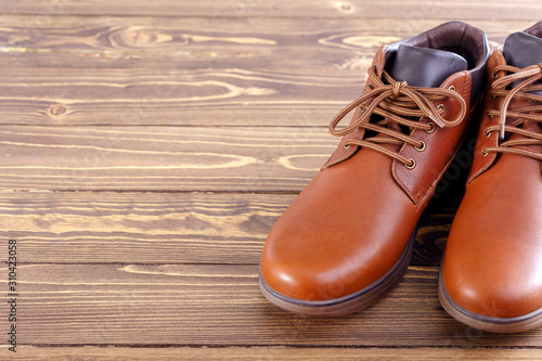 Stylish men's shoes on a wooden background with copy space.