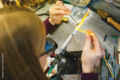Artist in workshop making glass bead
