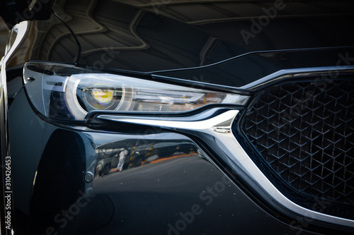 Modern luxury car close-up banner background,Concept of expensive, sports auto,Car back lights shining in the dark,headlight of modern prestigious car closeup.
