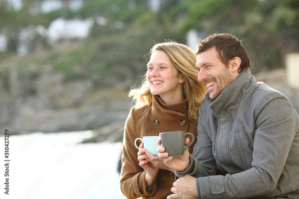 Happy couple of adults dating in winter on the beach Happy couple of adults dating in winter on the beach