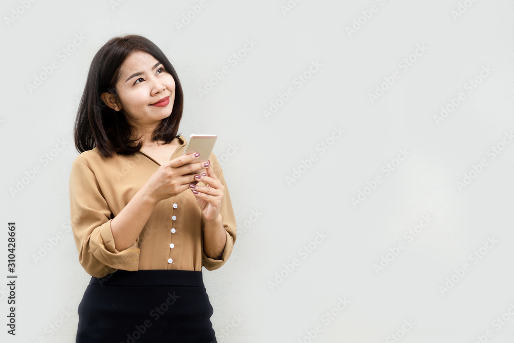happy Asian business woman using smart phone smiling and look up to empty wall happy Asian business woman using smart phone smiling and look up to empty wall