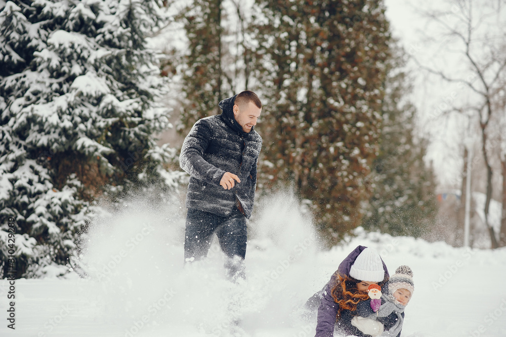 Family have fun in a winter park. Stylish mother in a purple jacket. Little girl in a winter clothes. Father with cute daughter Family have fun in a winter park. Stylish mother in a purple jacket. Little girl in a winter clothes. Father with cute daughter