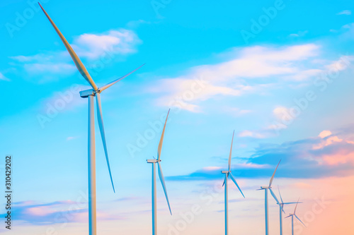 Wind turbine farm with rays of light at sun