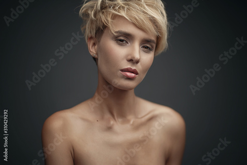 portrait of a young attractive blonde girl on a dark background