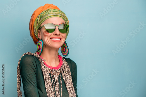 Fototapeta Beautiful woman with a turban on her head, fashion earrings and a bracelet