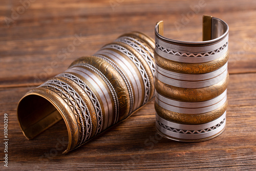 Beautiful wide bracelets close-up. Indian copper bracelets with gold ornaments. Ritual bracelets for women.