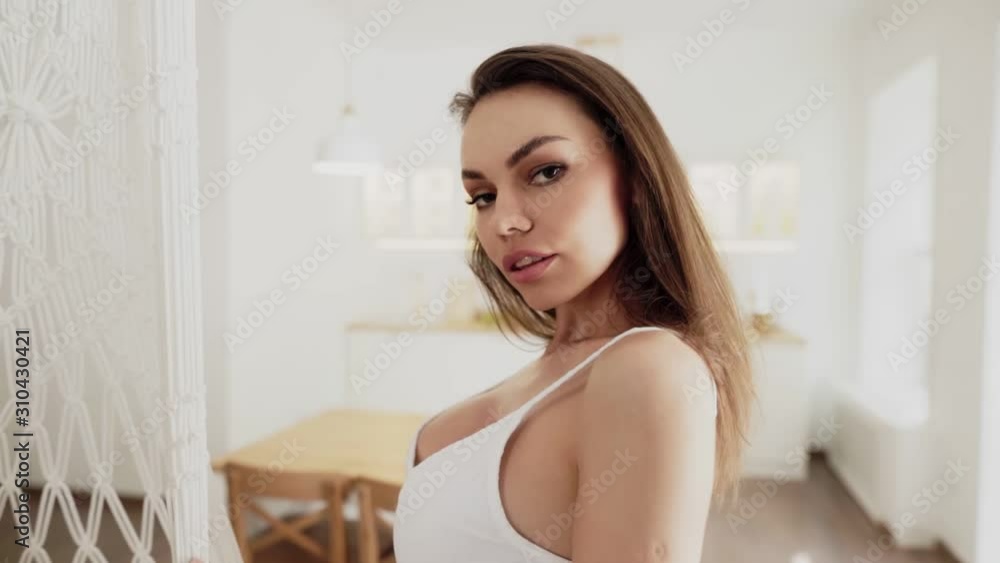 Portrait of Beautiful sexy woman in white lingerie standing in the kitchen Portrait of Beautiful sexy woman in white lingerie standing in the kitchen