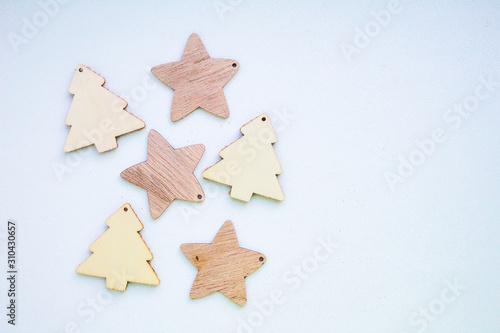 Christmas wooden toys on the Christmas tree in the shape of stars and Christmas trees on a white background, on the right side a place for text, copy space