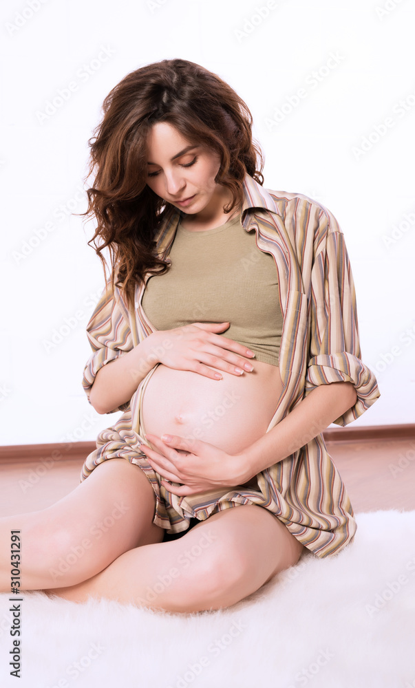 Vertical shot of a young and attractive pregnant woman. Vertical shot of a young and attractive pregnant woman.