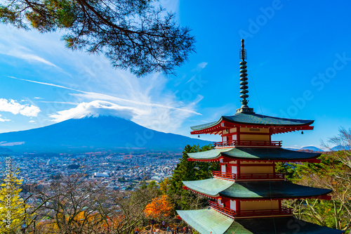 Beautiful view from Chureito Pagoda in Autumn season with mountain Fuji wearing hat in the background. Fujiyoshida, Japan.