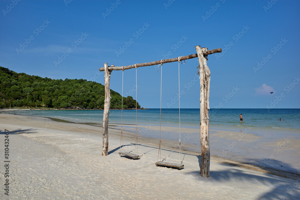 Phu Quoc island, Vietnam - March 27, 2019: Swaying palm tree on Sao beach, one of the most beautiful tropical sandy beaches in Phu Quoc