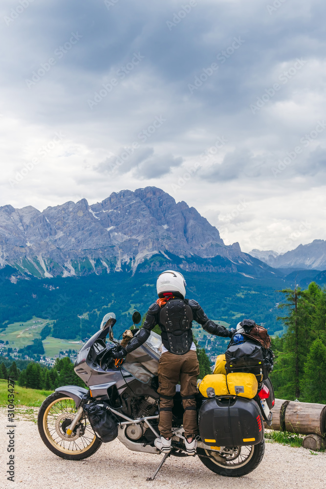 Woman biker with adventure touring motorcycle in full equipment on dirt road, Woman biker with adventure touring motorcycle in full equipment on dirt road,