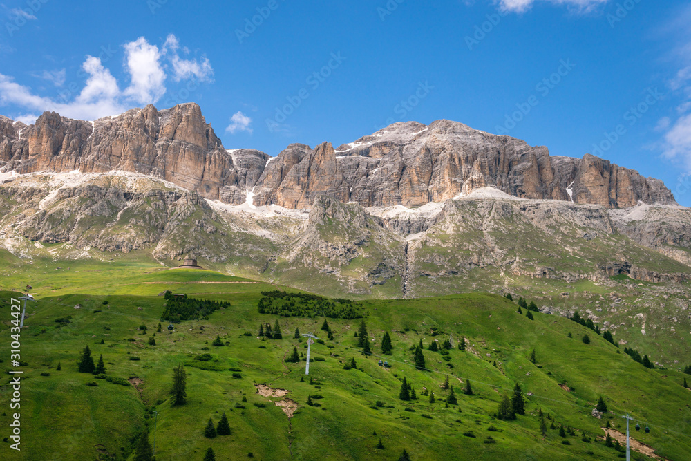 Panoramic view on the Sella massif and Piz Boe. Dolomites, Italy, Beautiful sunny summer day, green hills blue sky Passo Pordoi