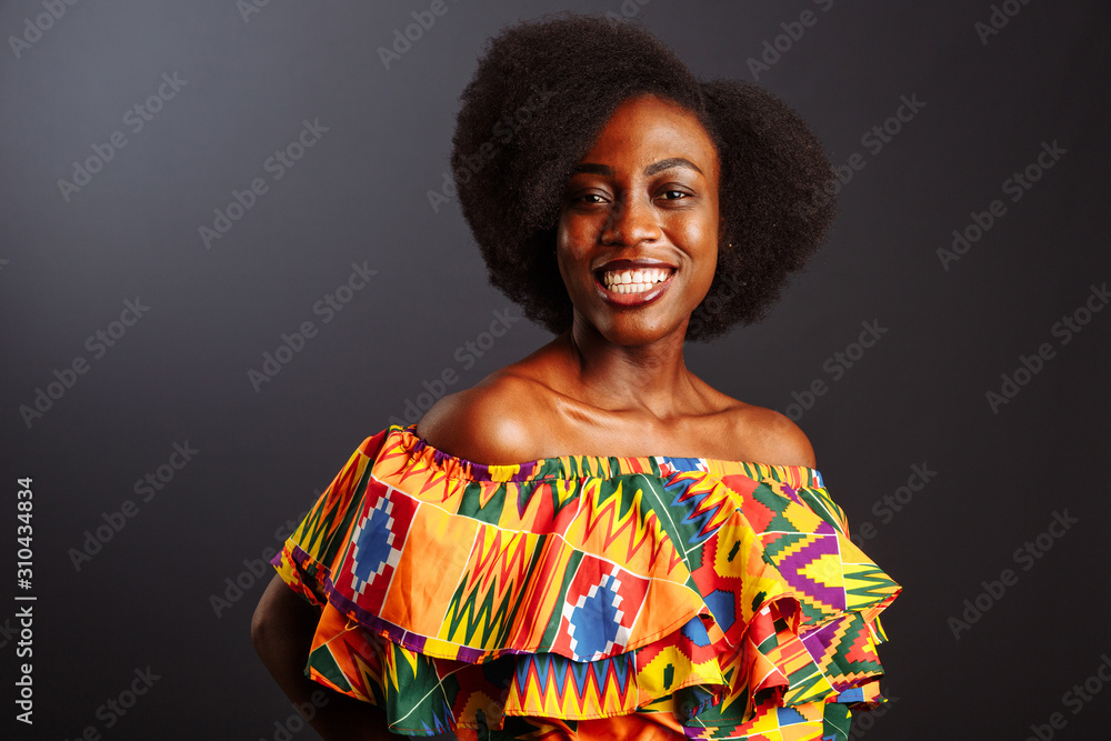 Young African woman from Ivory Coast in traditional clothes posing and smiling at camera