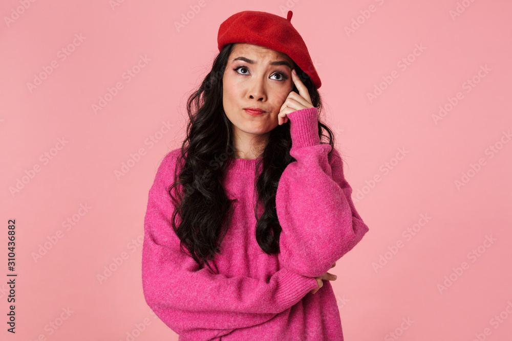 Image of thoughtful beautiful asian girl wearing beret thinking or hesitating Image of thoughtful beautiful asian girl wearing beret thinking or hesitating