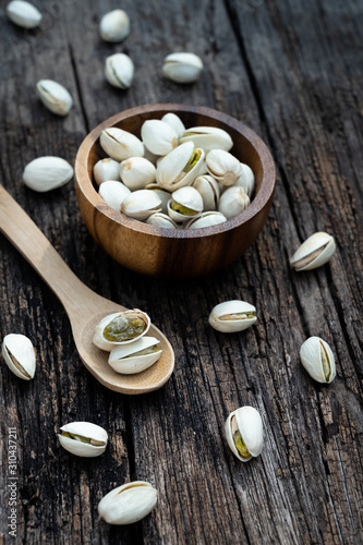 Pistachio nut in wooden bowl on rusty wood table background