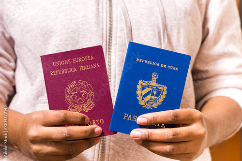 Black Woman Holding Two Passports. Official Cuban and Italian passport