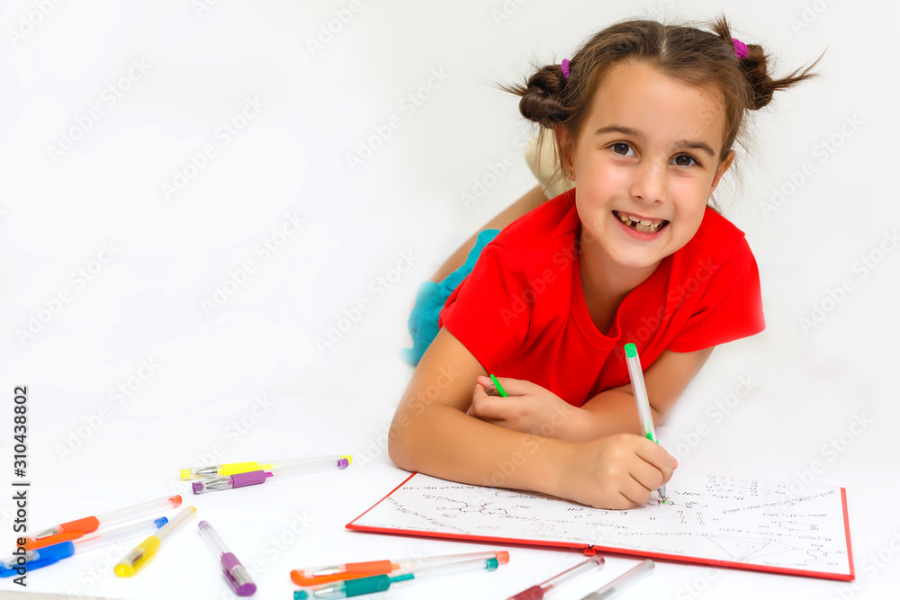 Happy little girl practicing reading laying on the floor in her room Happy little girl practicing reading laying on the floor in her room