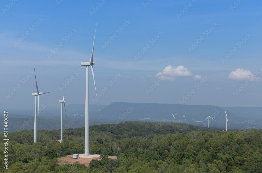 Mountain wind turbines for generating electricity Behind the mountains in the sky, there are white clouds on a sunny day. Mountain wind turbines for generating electricity Behind the mountains in the sky, there are white clouds on a sunny day.