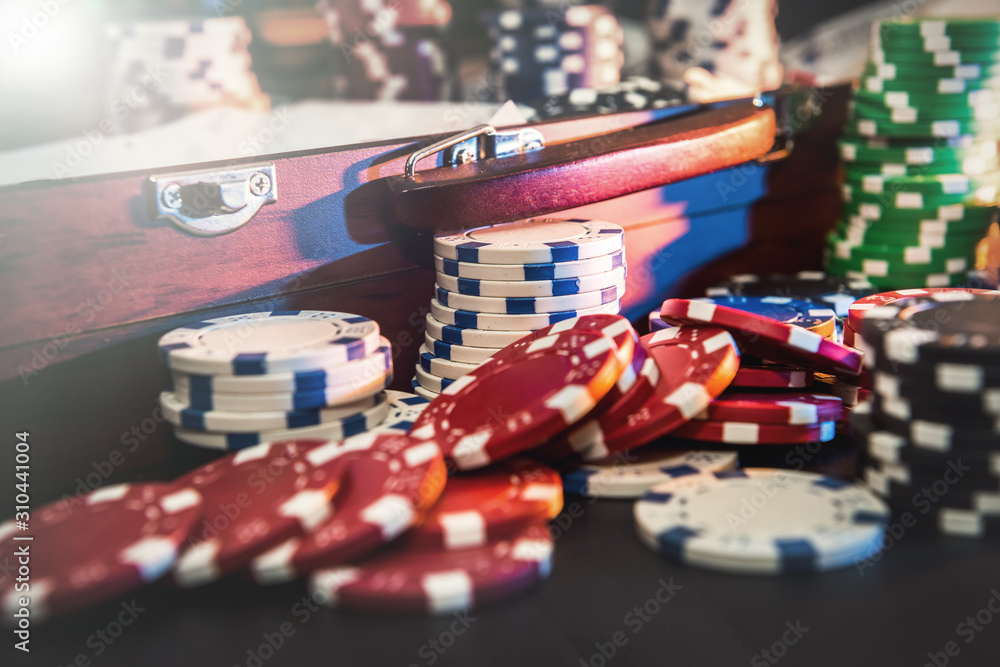 Gambling background. Colorful poker chips on playing table with wooden box for them Gambling background. Colorful poker chips on playing table with wooden box for them